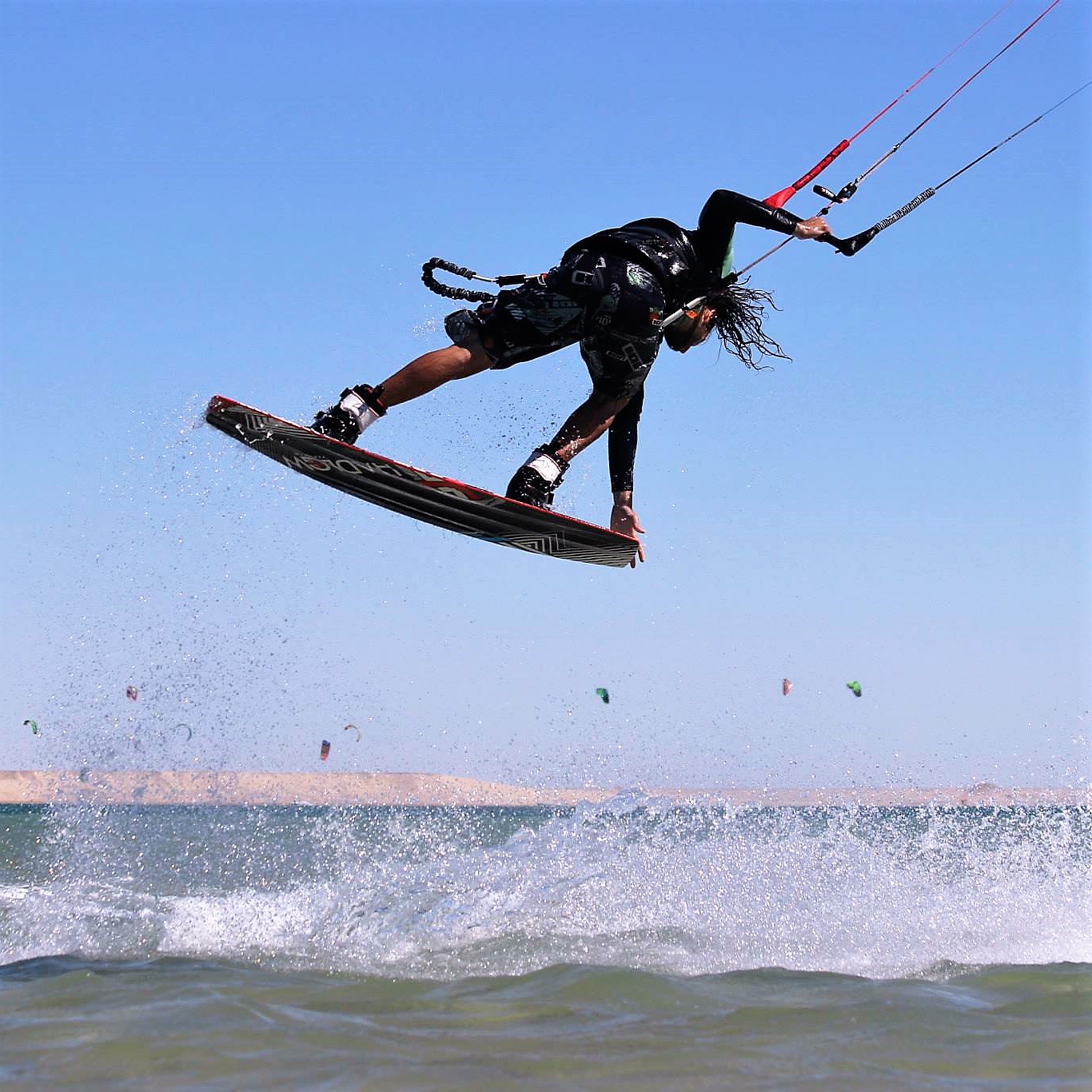 Active holidays in Egypt: kitesurfing. A kitesurfer performs a grab.