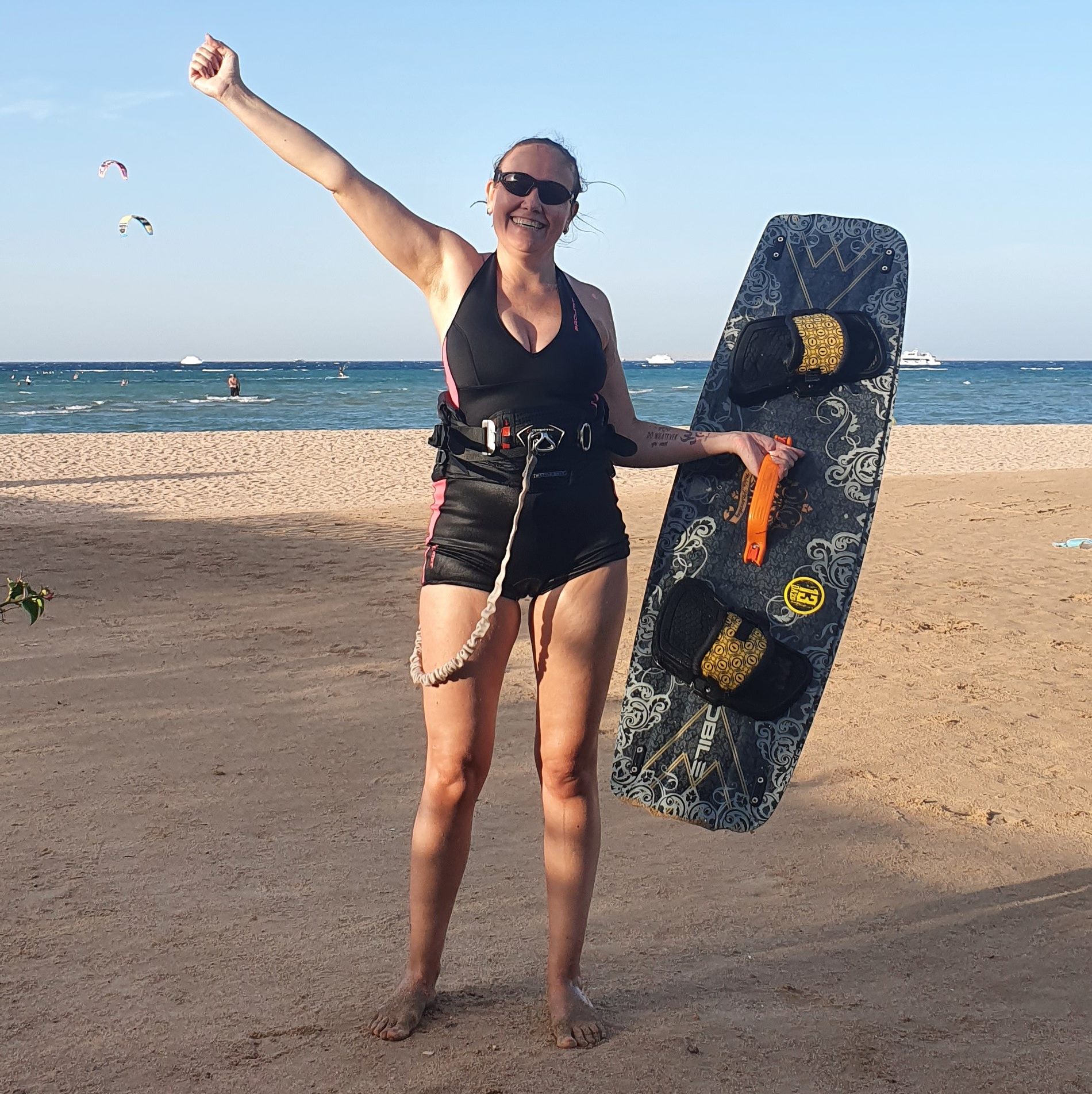 A student of a kitesurfing school salutes cheerfully
